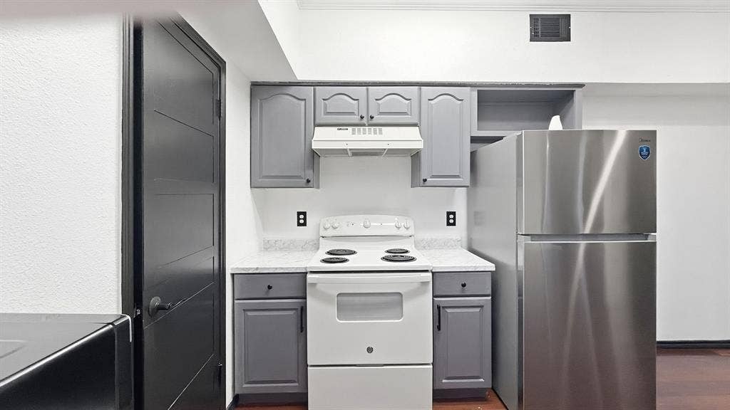 1700 Amelia Court, #126, Plano, TX 75075 Kitchenette featuring gray cabinetry, stainless steel refrigerator, white electric range, and light-toned countertops