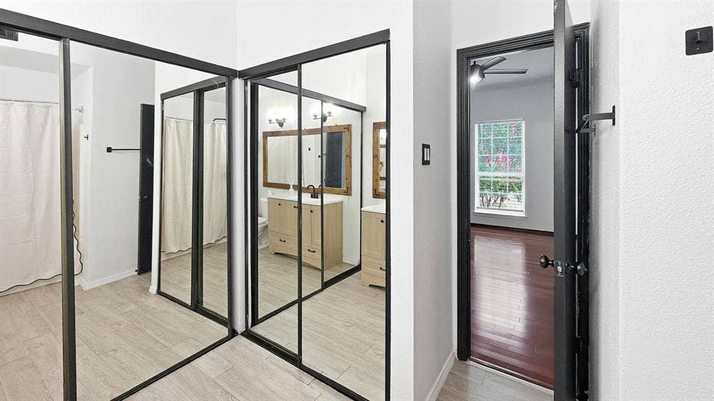 1700 Amelia Court, #126, Plano, TX 75075 Mirrored closet doors, light-toned tile flooring, white walls, dark wood-finish flooring, and a ceiling fan