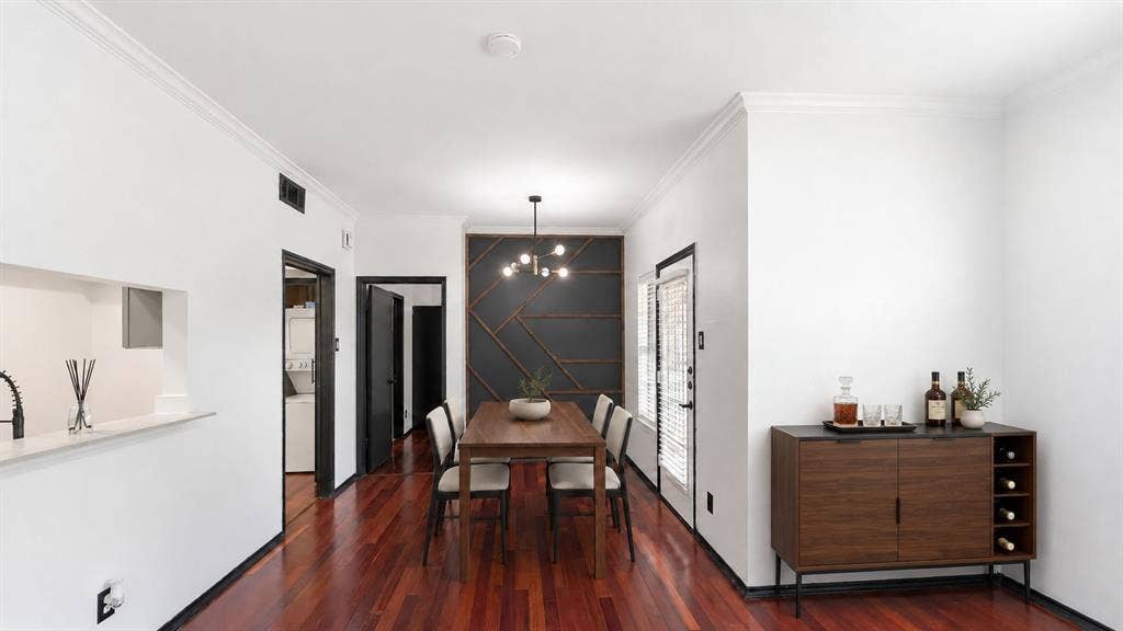 1700 Amelia Court, #126, Plano, TX 75075 Rich wood-finish flooring, accent wall with geometric paneling, modern ceiling-mounted light fixture, and crown molding Virtually Staged
