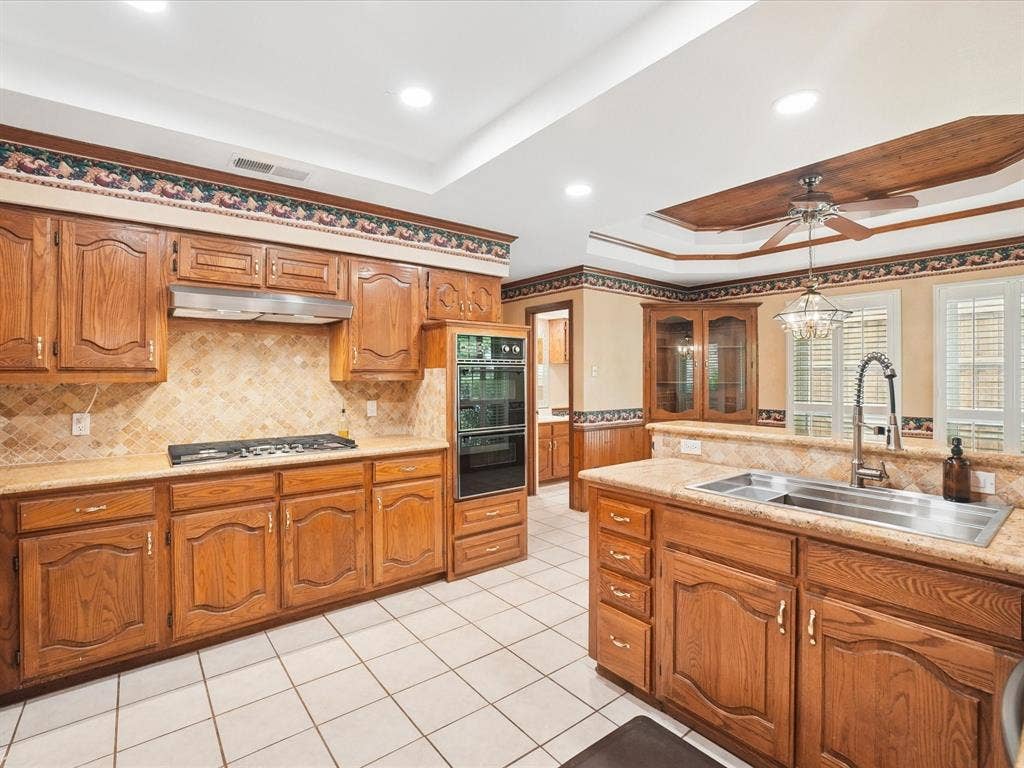1304 Carriage Creek Drive, DeSoto, TX 75115 Kitchen featuring wood-finish cabinetry, tile flooring, recessed lighting, and a double basin sink