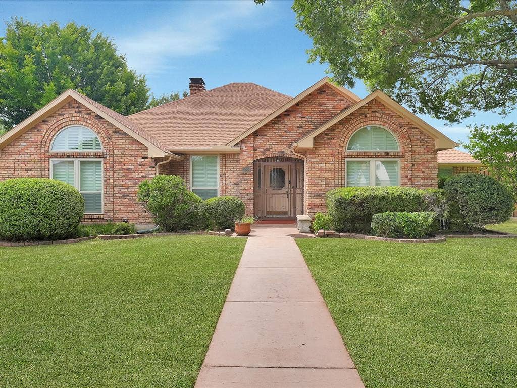 1304 Carriage Creek Drive, DeSoto, TX 75115 Brick exterior with a gabled roof and arched windows