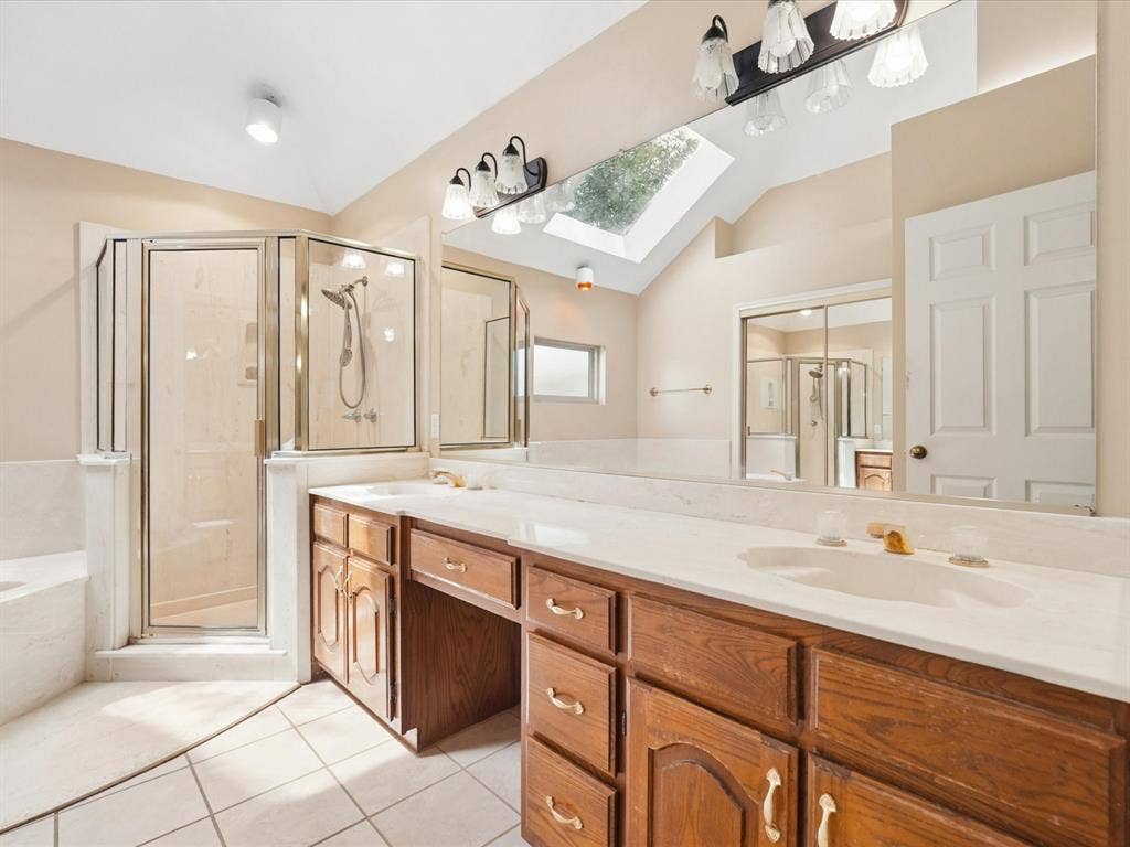1304 Carriage Creek Drive, DeSoto, TX 75115 Dual vanity with integrated sinks, wood-finish cabinetry, and a spacious countertop