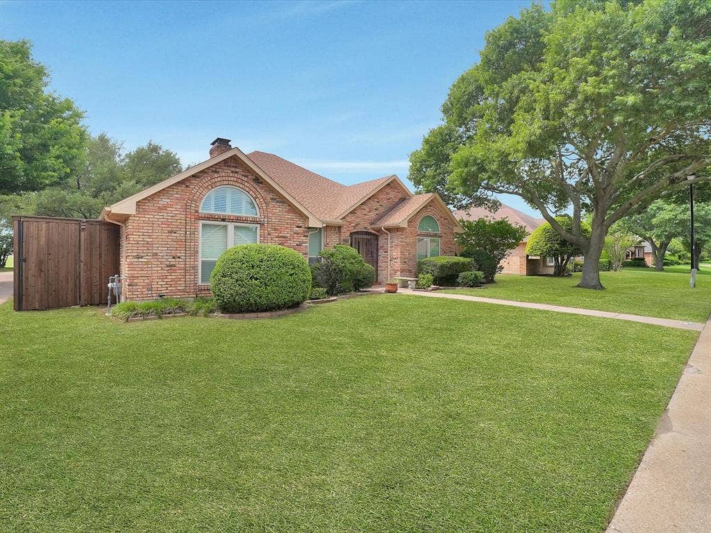 1304 Carriage Creek Drive, DeSoto, TX 75115 Brick exterior with architectural arch window and a gabled roof