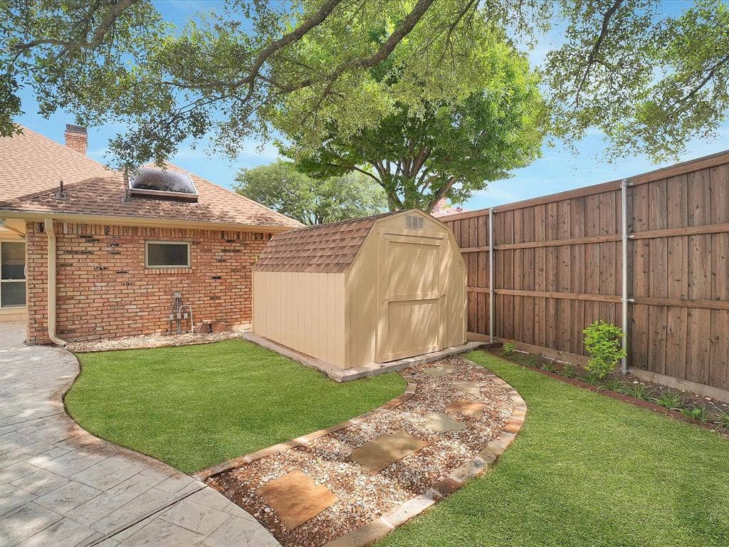 1304 Carriage Creek Drive, DeSoto, TX 75115 Private yard with a patterned concrete patio, a stepping stone pathway, and a wooden privacy fence