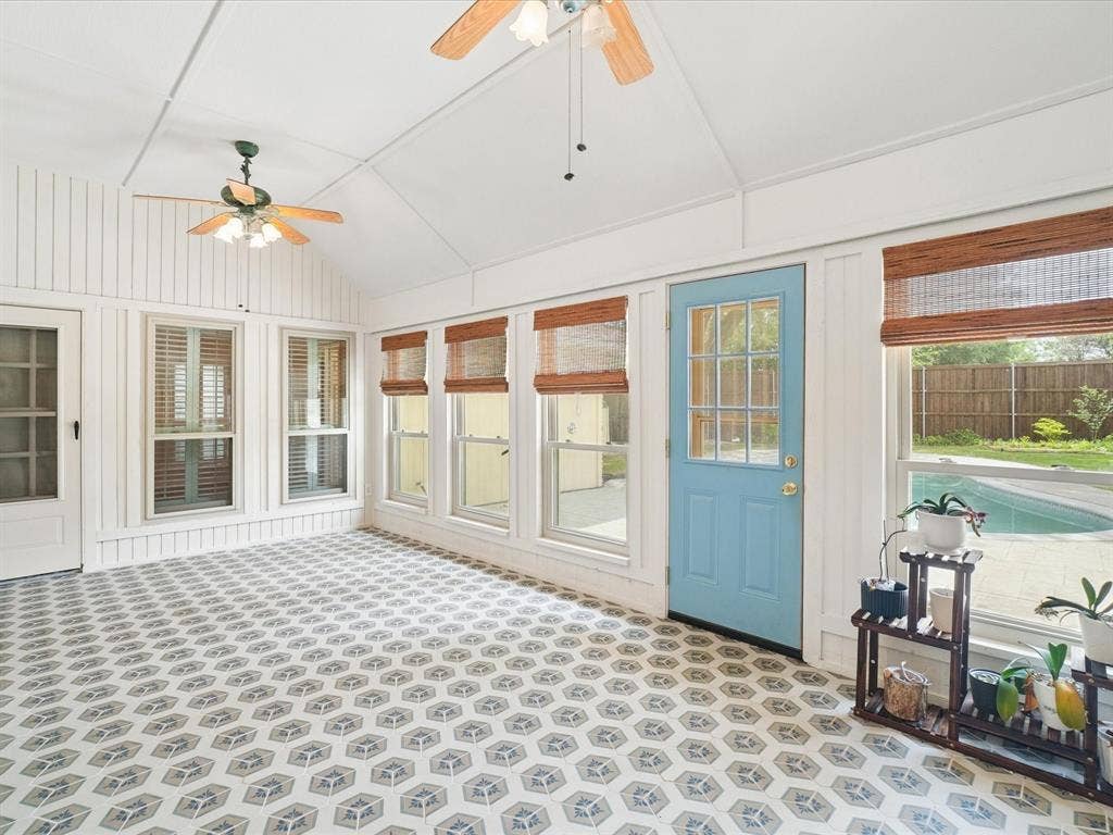1304 Carriage Creek Drive, DeSoto, TX 75115 Vaulted ceiling with exposed beams, decorative ceiling fans, patterned tile flooring, multiple windows with blinds, and an exterior door with glass panels
