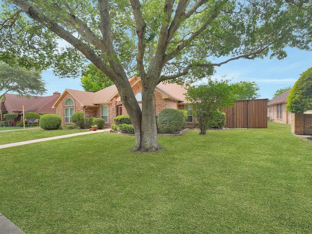 1304 Carriage Creek Drive, DeSoto, TX 75115 Brick exterior, gabled roof, arched window, mature tree, manicured lawn