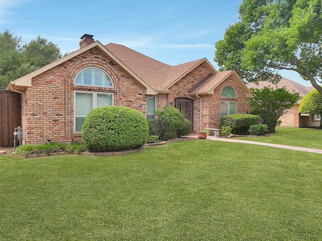 1304 Carriage Creek Drive, DeSoto, TX 75115 Brick exterior with arched windows, gabled roofline, and established landscaping