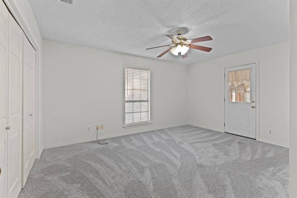 1656 Pineview Lane, Hideaway, TX 75771 Wall-to-wall carpeting, ceiling fan with integrated lighting, glass-paneled door, and louvered window blinds