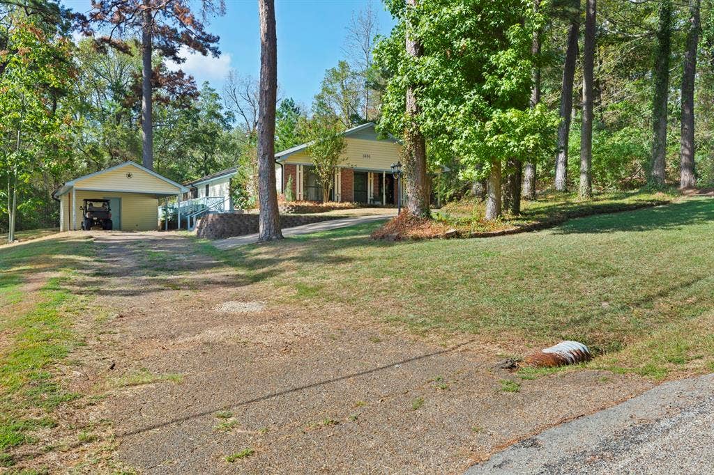 1656 Pineview Lane, Hideaway, TX 75771 Property featuring mature trees and a detached garage with a covered carport