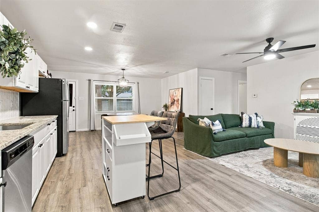 Open-concept living area featuring wood-finish flooring, recessed lighting, and a ceiling fan