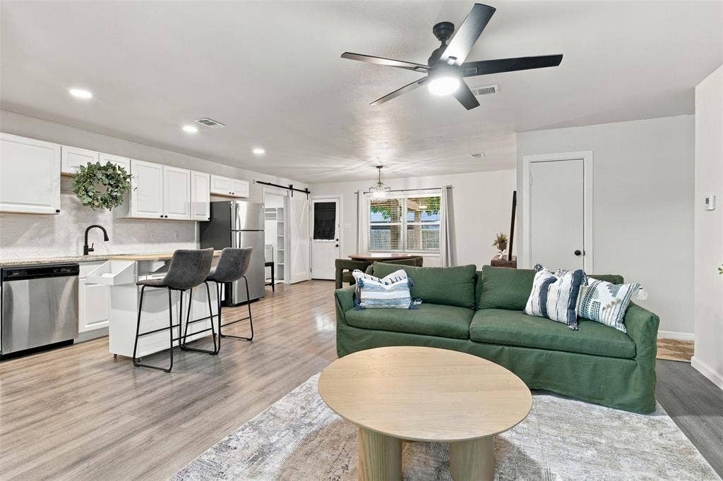 Open-concept living area with wood-finish flooring, recessed lighting, and a ceiling fan