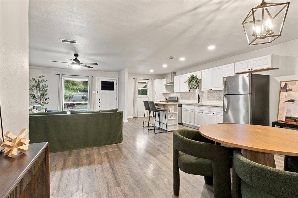 Open-concept living space featuring wood-finish flooring, recessed lighting, and a ceiling fan