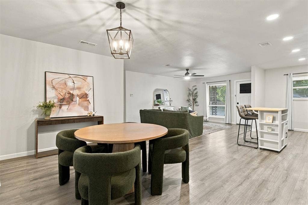 Open-concept living area featuring wood-finish flooring, recessed lighting, and a contemporary chandelier
