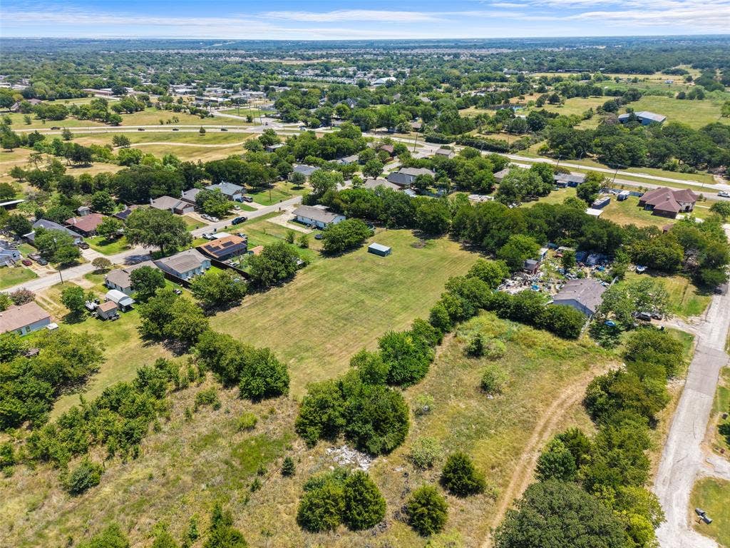 74 Sarah Lane, Dallas, TX 75253 Expansive property featuring a large open field, surrounding residential structures, and mature trees