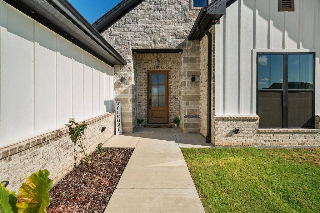 16139 Eagle Lane, Lindale, TX 75771 Stone and board-and-batten exterior with a wood-panel front door