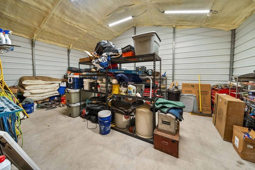 16139 Eagle Lane, Lindale, TX 75771 Corrugated metal walls with a high ceiling, concrete flooring, and fluorescent lighting