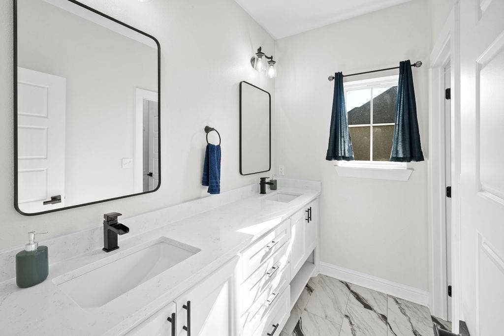 16139 Eagle Lane, Lindale, TX 75771 Dual vanity with integrated sinks, white cabinetry, matte black hardware, and an expansive countertop