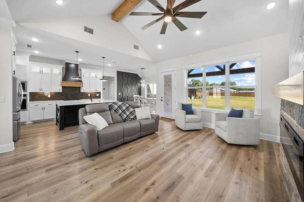 16139 Eagle Lane, Lindale, TX 75771 Vaulted ceiling with exposed wood beam, wood-finish flooring, recessed lighting, expansive windows, and a built-in fireplace