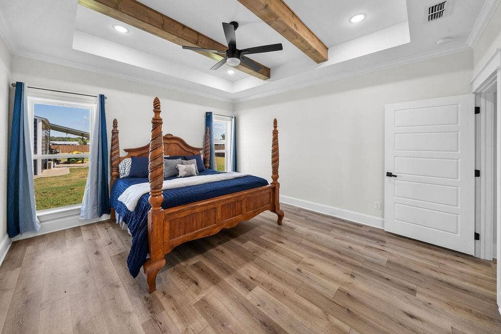 16139 Eagle Lane, Lindale, TX 75771 Wood-finish flooring throughout, tray ceiling with recessed lighting, exposed ceiling beams, ceiling fan, and white paneled door with black hardware