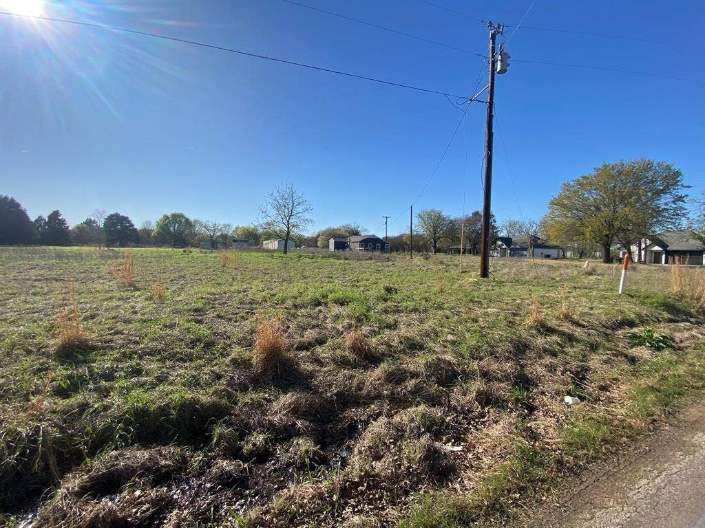 421 Kelly Lane, Seven Points, TX 75143 Expansive open land featuring a clear blue sky, distant foliage, and utility pole