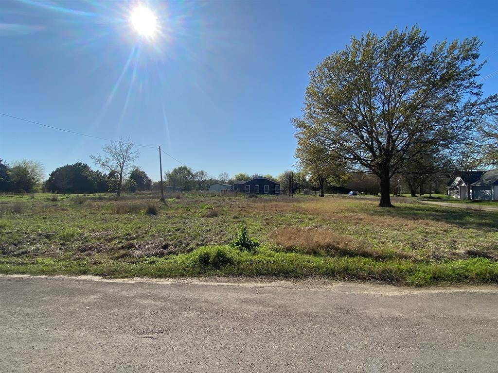 421 Kelly Lane, Seven Points, TX 75143 Expansive open lot with mature trees and a clear sky