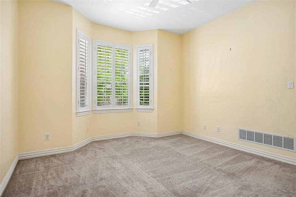 8141 Rosemont Drive, Plano, TX 75025 Large secondary bedroom with bay window, shutters, ceiling fan.