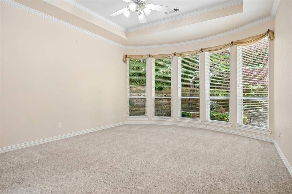 8141 Rosemont Drive, Plano, TX 75025 Huge Primary bedroom with curved wall of windows, tray ceiling, ceiling fan.