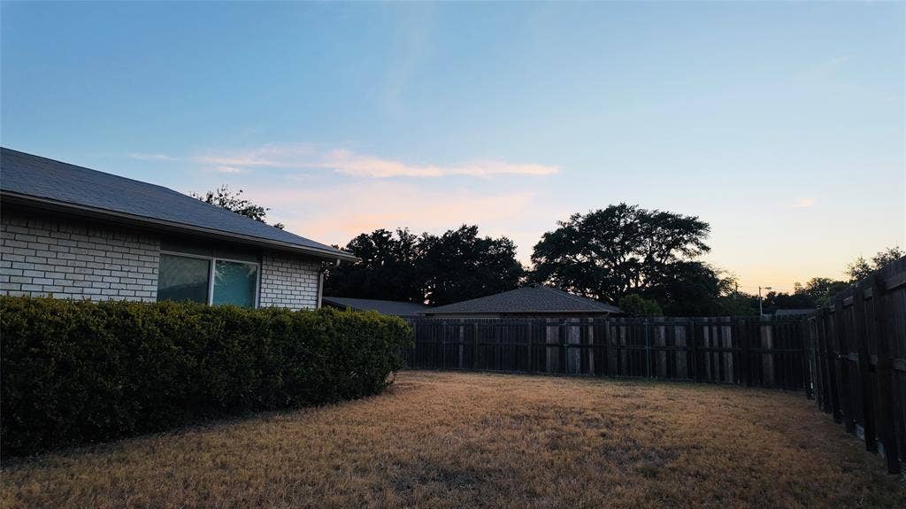 6541 Santa Fe Trail, Plano, TX 75023 Brick exterior with a dark roof and a perimeter hedge