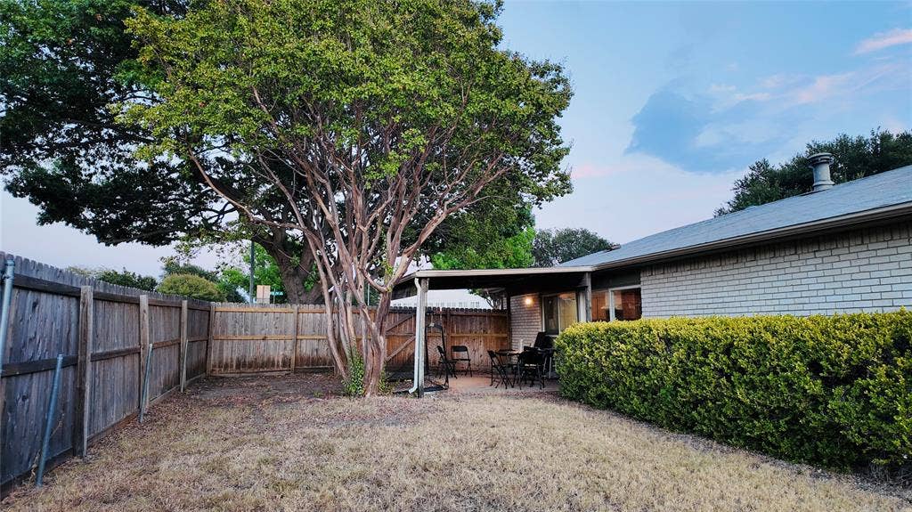 6541 Santa Fe Trail, Plano, TX 75023 Private backyard with wood fencing, mature trees, and a covered patio