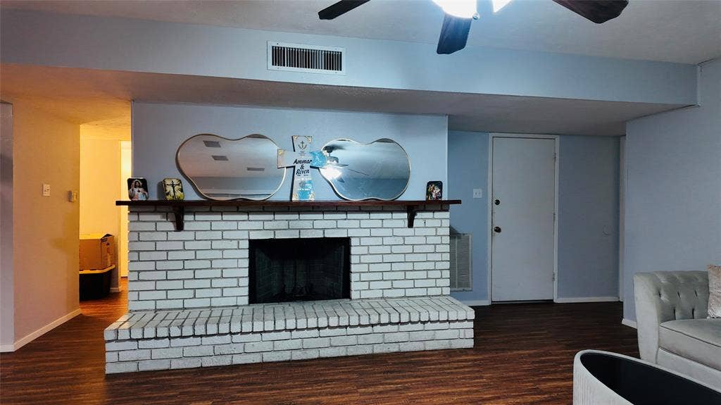 6541 Santa Fe Trail, Plano, TX 75023 White brick fireplace with a wood-finish mantel and hearth