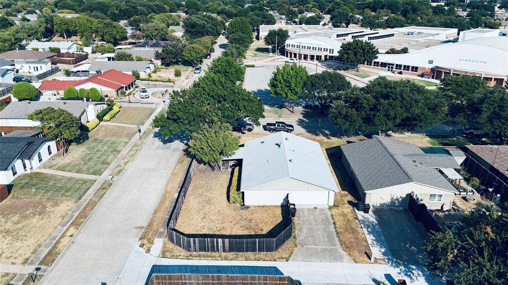 6541 Santa Fe Trail, Plano, TX 75023 Single-story residence with an attached two-car garage, concrete driveway, and fenced backyard