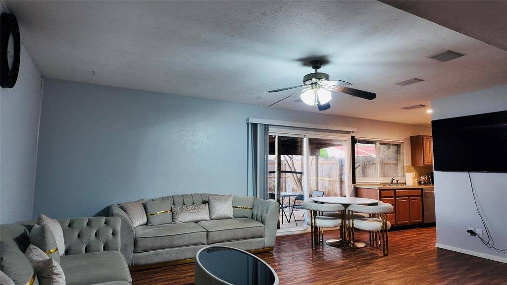 6541 Santa Fe Trail, Plano, TX 75023 Wood-finish flooring throughout, ceiling fan with integrated lighting, sliding glass door access to exterior, kitchen with wood cabinetry and stainless steel appliances, recessed ceiling lights
