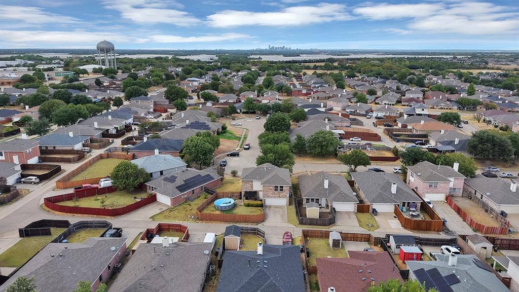 2326 Mcintosh Court, Lancaster, TX 75134 Residential neighborhood with a water tower, a distant cityscape, and a body of water in the background