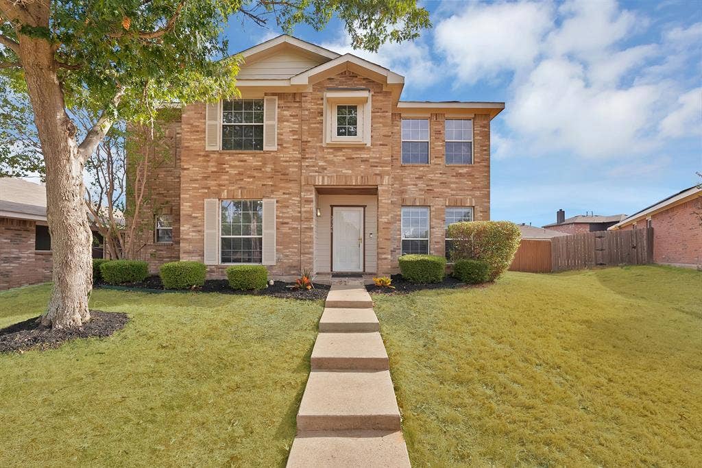 2326 Mcintosh Court, Lancaster, TX 75134 Two-story brick exterior with light-colored shutters, a prominent front entry, a concrete walkway, and established landscaping