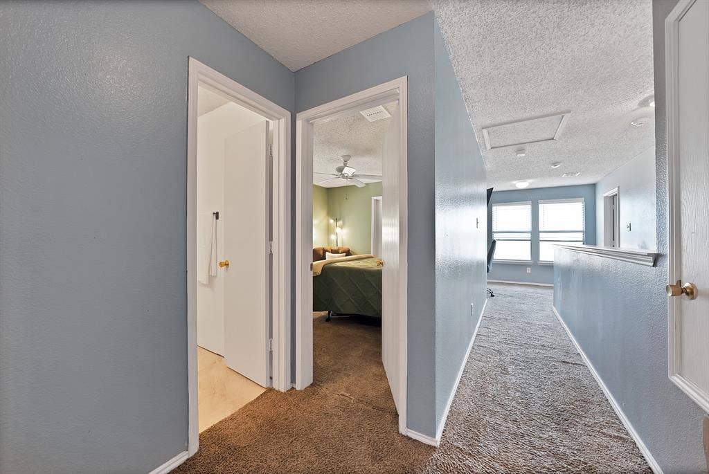 2326 Mcintosh Court, Lancaster, TX 75134 Hallway featuring a built-in half wall, access panel, and wall-mounted lighting