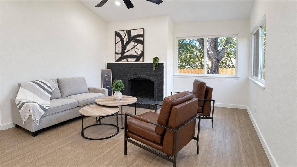 2417 Via Barcelona, Carrollton, TX 75006 Spacious living area featuring light wood-finish flooring, white walls, and multiple windows