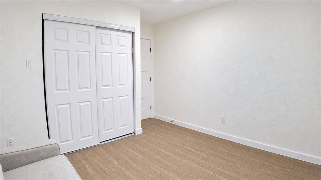 2417 Via Barcelona, Carrollton, TX 75006 Light wood-finish flooring, white walls, and a white six-panel sliding closet door