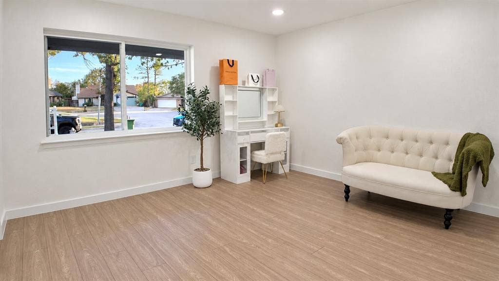 2417 Via Barcelona, Carrollton, TX 75006 Bright room featuring wood-finish flooring, white walls, and a large window