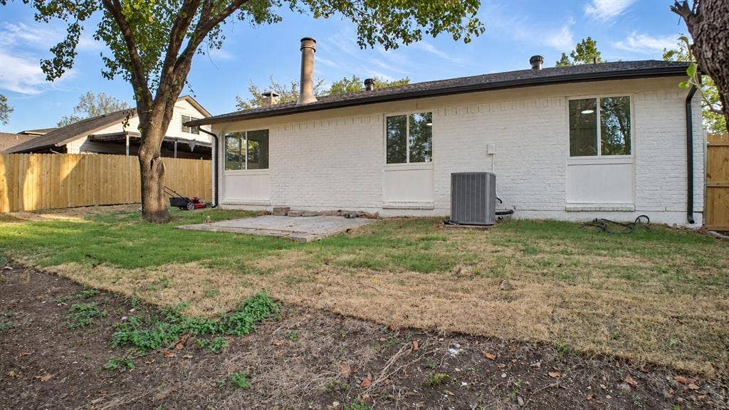 2417 Via Barcelona, Carrollton, TX 75006 White brick exterior with a dark roof and multiple windows