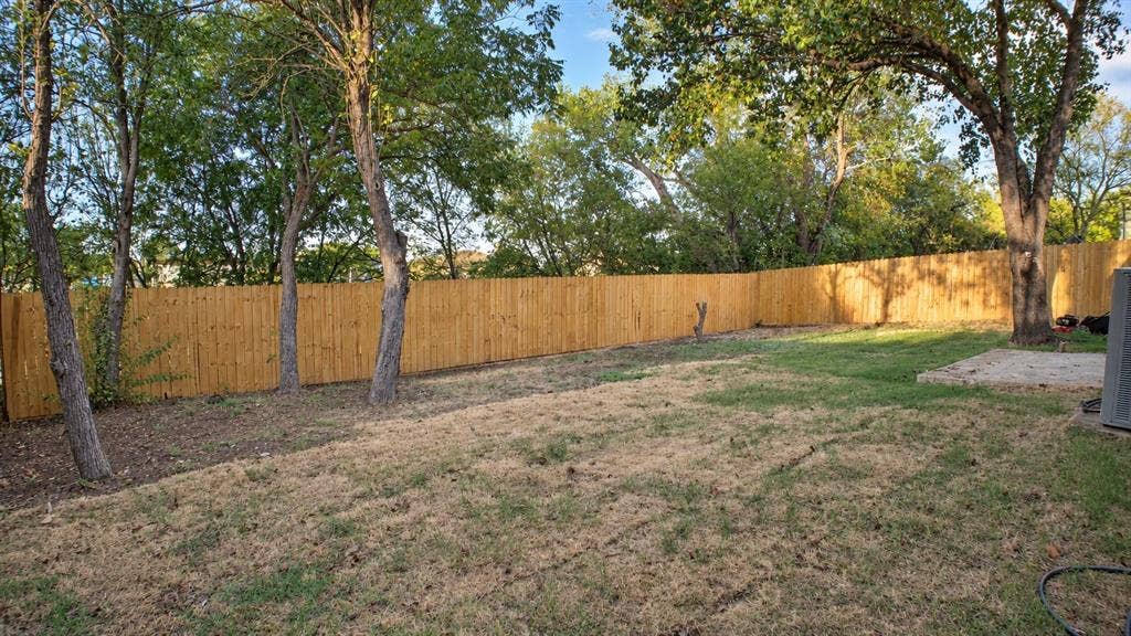 2417 Via Barcelona, Carrollton, TX 75006 Expansive backyard featuring a wood privacy fence and mature trees