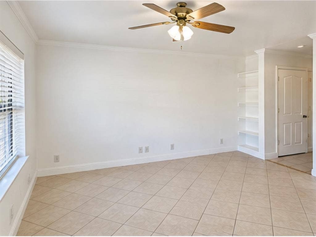 1919 American Drive, #B112, Lago Vista, TX 78645 Recessed built-in shelving, ceiling fan with light fixture, large window with blinds, crown molding, and tile flooring