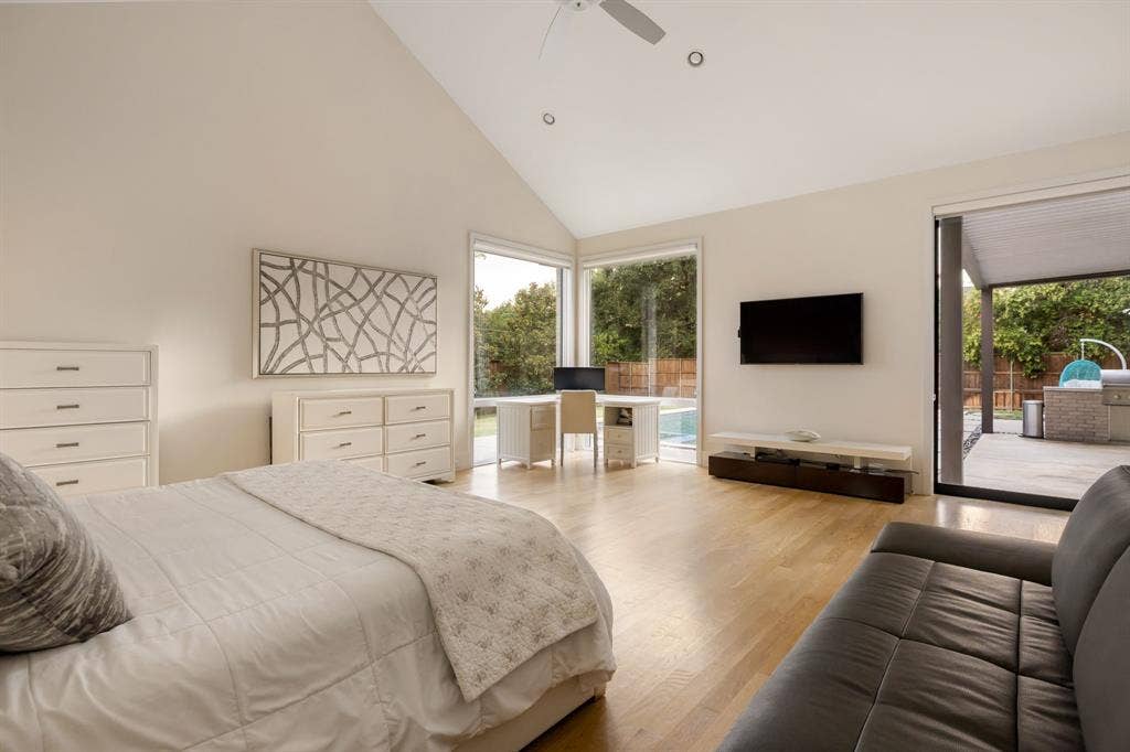 5724 Charlestown Drive, Dallas, TX 75230 Vaulted ceiling with recessed lighting, wood-finish flooring, corner window, sliding glass door, and an outdoor patio with a built-in grill