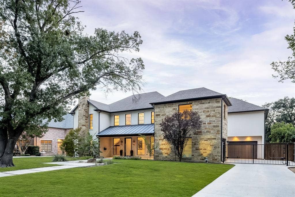 5724 Charlestown Drive, Dallas, TX 75230 Stone and stucco exterior, covered entry, black metal roof accent, concrete driveway, and black metal security gate
