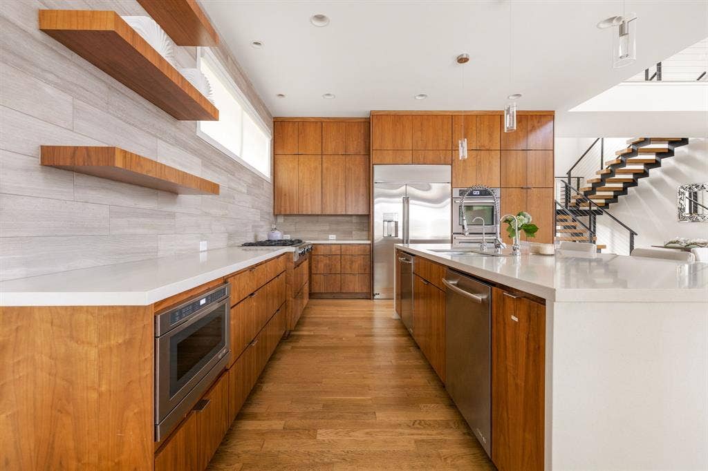 5724 Charlestown Drive, Dallas, TX 75230 Hardwood flooring throughout, extensive wood cabinetry, stainless steel appliances, white countertops, and a modern open-tread staircase