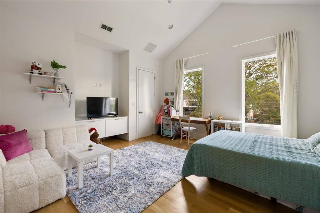 5724 Charlestown Drive, Dallas, TX 75230 Vaulted ceiling, two tall windows, wood-finish flooring, built-in shelving, and a built-in media console