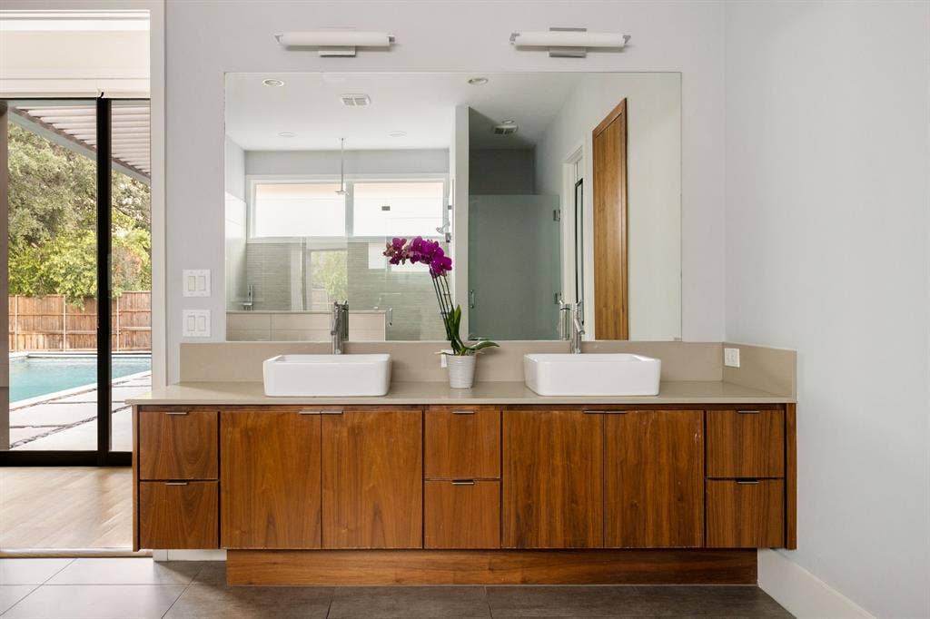 5724 Charlestown Drive, Dallas, TX 75230 Double vanity featuring wood-finish cabinetry and a light-toned countertop