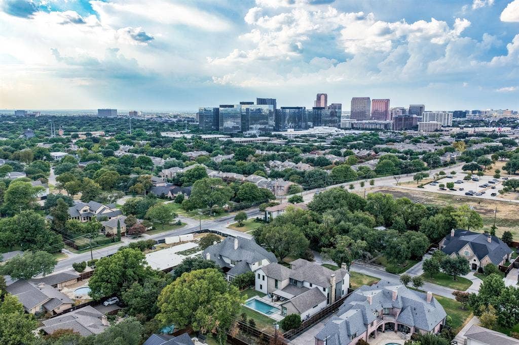5724 Charlestown Drive, Dallas, TX 75230 Aerial perspective featuring residential properties, mature tree canopy, and distant city skyline