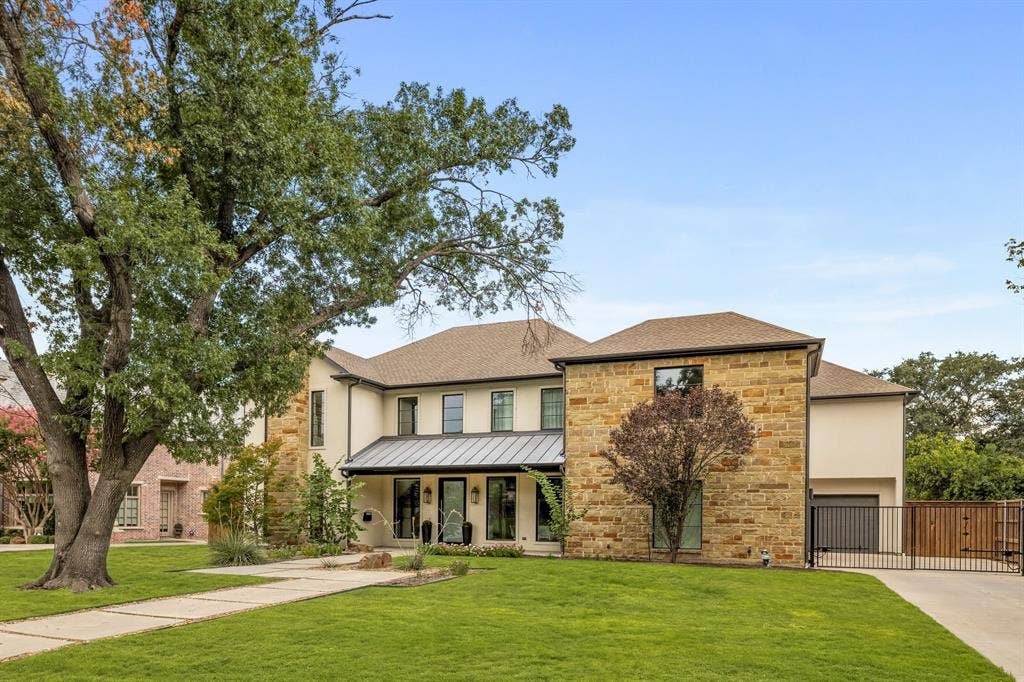 5724 Charlestown Drive, Dallas, TX 75230 Stucco and stone exterior with a covered entry, dark-framed windows, and a metal roof accent