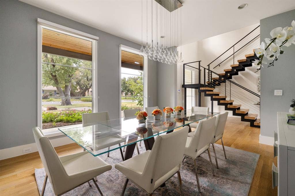 5724 Charlestown Drive, Dallas, TX 75230 Hardwood flooring, floor-to-ceiling windows, modern floating staircase with black railings, high ceilings, and a contemporary chandelier