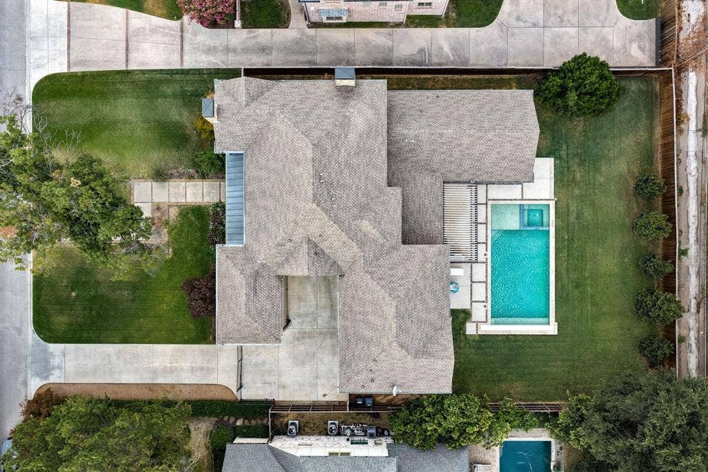 5724 Charlestown Drive, Dallas, TX 75230 Expansive property featuring a multi-gabled roofline, concrete driveway, and a large inground swimming pool with an integrated spa